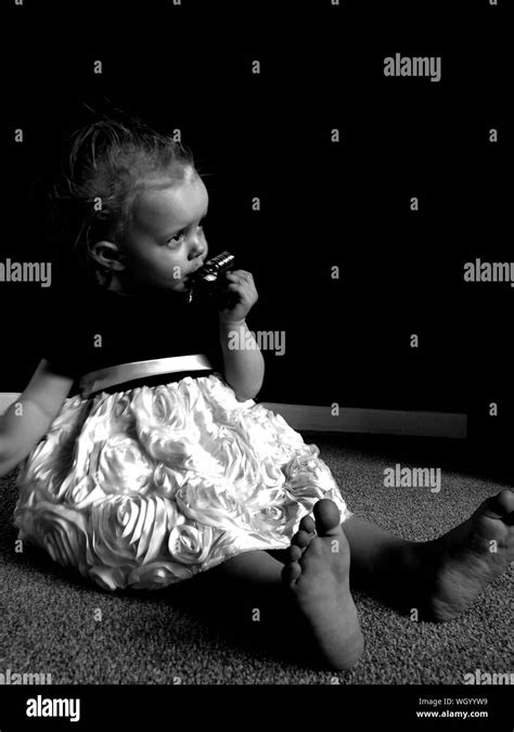 Cute Baby Girl Sitting On Carpet Stock Photo Alamy