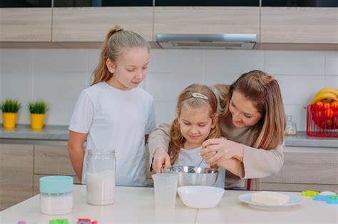 Mamá Les Enseña A Sus Hijas A Cocinar Masa En La Cocina Foto Premium