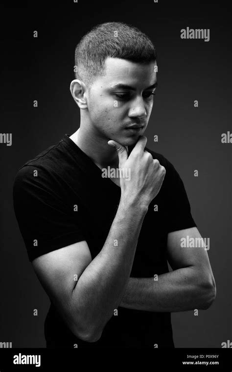 Young Multi Ethnic Asian Man Against Black Background In Black A Stock