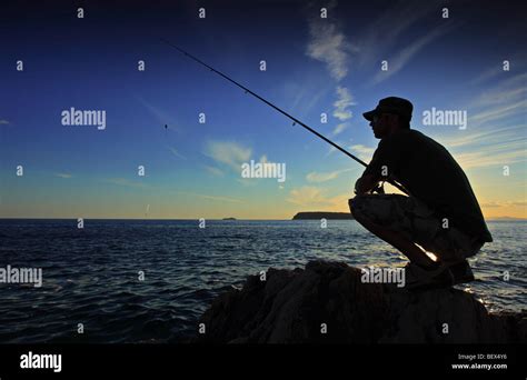 Man Fishing On Sunset Stock Photo Alamy