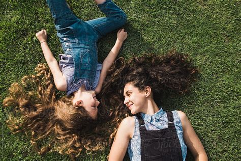Mother And Daughter Laying On The Green Grass Looking At Each Other By Stocksy Contributor