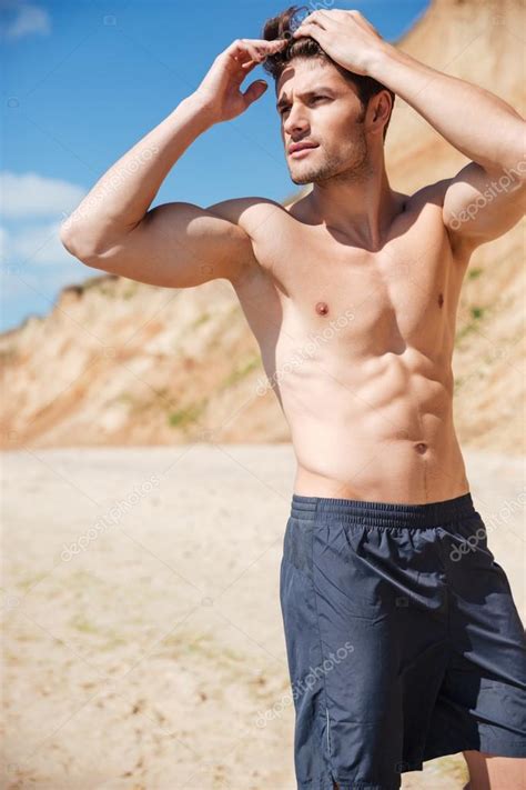 Attractive Shirtless Young Man Standing On Beach — Stock Photo