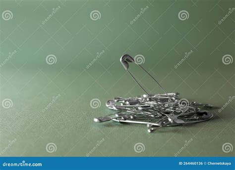 Pile Of Safety Pins On Green Background Space For Text Stock Photo