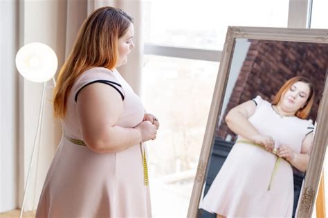 Mulher Gordinha E Simp Tica Olhando No Espelho Enquanto Mede A Cintura Foto Premium