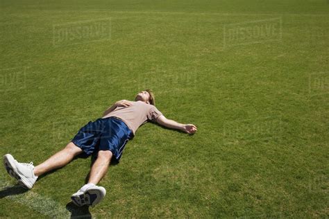 Defeated Athlete Lying On Grass Stock Photo Dissolve