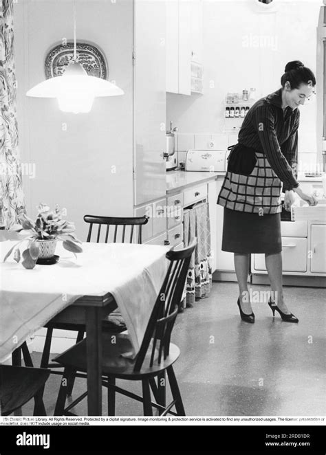 In The Kitchen 1960s Interior Of A Kitchen And A Women Taking Something From A Kitchen Drawer