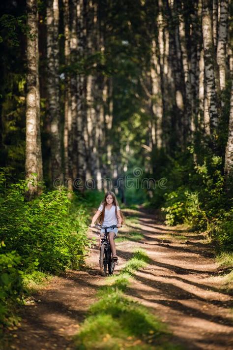 Children Girl Riding Bicycle Outdoor In Forest Smiling Stock Image