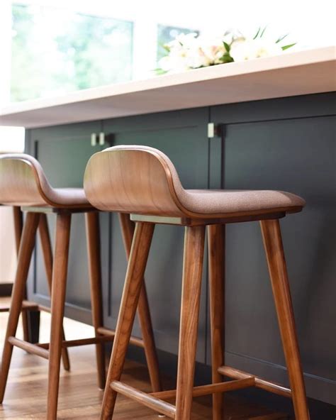 Three Wooden Stools Sitting Next To Each Other On A Counter Top In A
