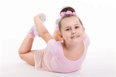 Little Happy Girl Gymnast Performs An Exercise On The Floor Holding His