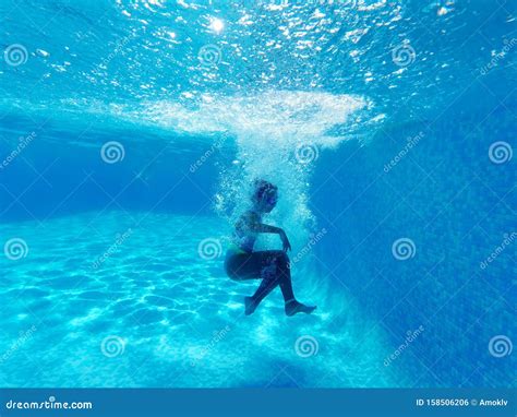 Underwater Photography Of Little Girl Dives To The Bottom Of Swimming