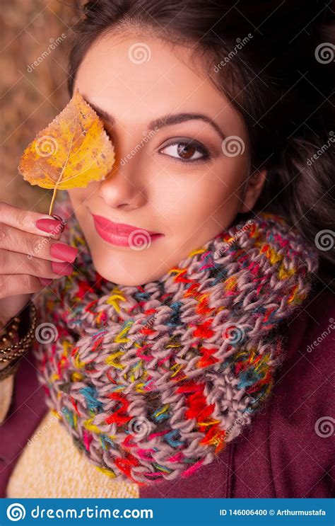Portrait Of A Gorgeous Romantic Young Woman Holding An Autumn Leaf In Front Of Her Right Eye
