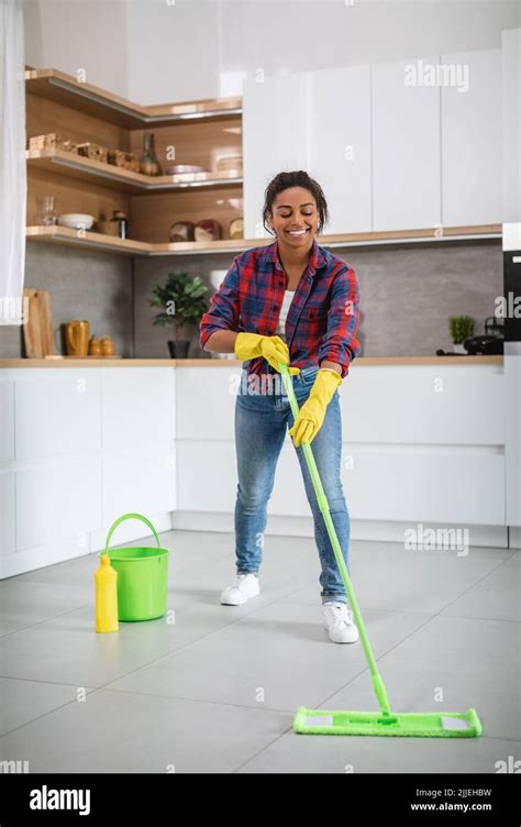 Cheerful Millennial African American Housewife In Rubber Gloves With