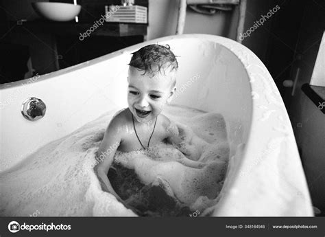 Черно белое фото мальчика плескающегося в ванной Вид обнаженных детей играющих в овальной