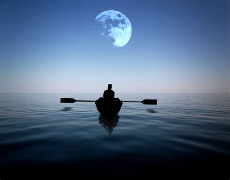 Man Riding On A Boat Alone In The Sea With Moon Hovering Above At Night