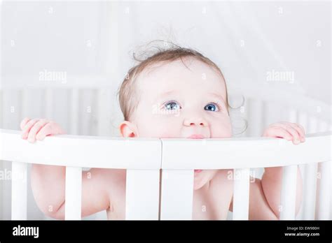 Funny Little Baby Biting On A Crib Stock Photo Alamy