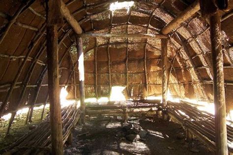The Inside Of An Old Hut With Wood Beams And Grass On The Floor Is