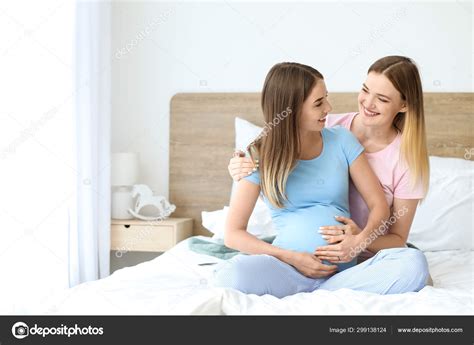 Happy Pregnant Lesbian Couple In Bedroom Stock Photo By Serezniy