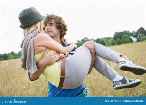 Romantic Man Carrying Woman In Field Stock Photo Image Of Daytime