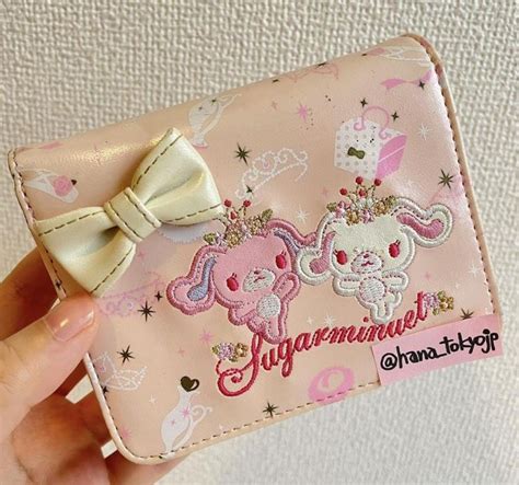 A Hand Holding A Pink Wallet With An Elephant On It And A Bow At The Top