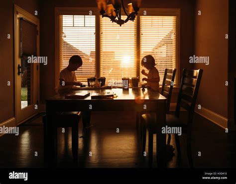 Boys Eating While Sitting At Dining Table Stock Photo Alamy