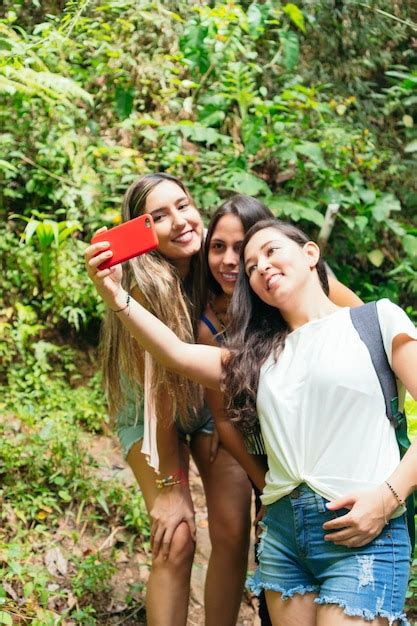 Amigas Latinas Se Toman Una Selfie Con Sus Teléfonos Celulares En Una Selva Tropical Foto Premium
