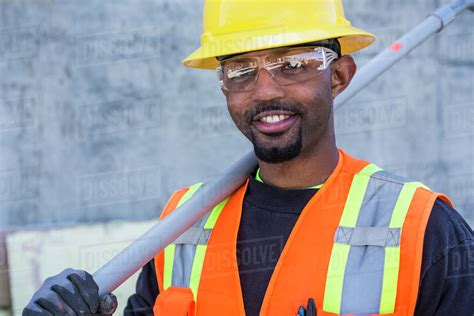 Black Worker Smiling On Construction Site Stock Photo Dissolve