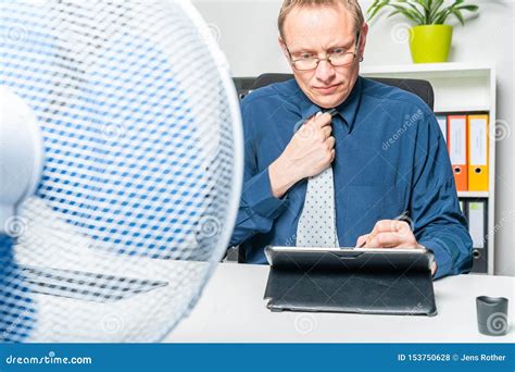 Businessman Is Working In Heat In The Office And Sweating Stock Photo