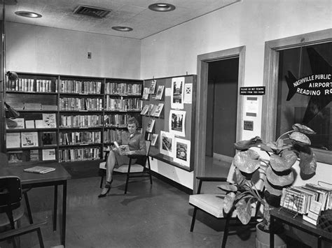 An Old Black And White Photo Of People In A Library With Books On The Shelves