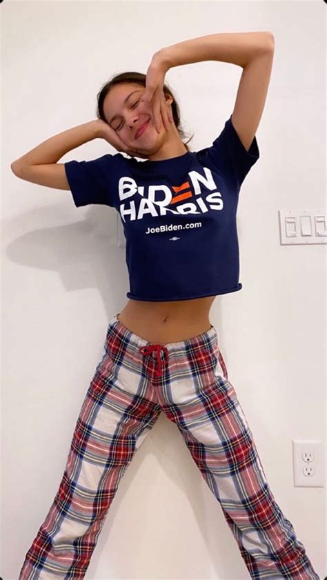 A Woman In Plaid Pants And A T Shirt Poses For The Camera With Her