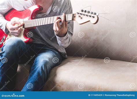 Casual Young Man Playing Guitar On Sofa At Home Stock Image Image Of