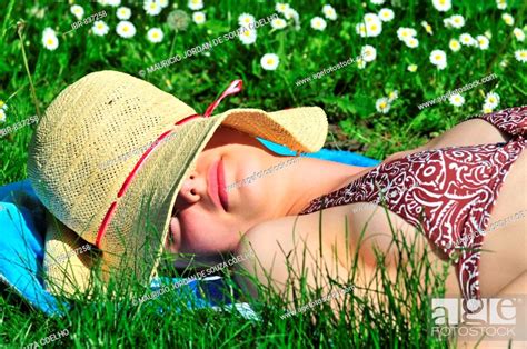 Woman Wearing A Bikini Sun Hat Lying In The Park Summer Sunbathing Sleeping Stock Photo