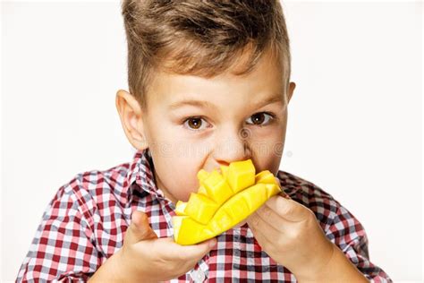 Handsome Boy In A Red Shirt Is Eating A Mango Stock Photo Image Of