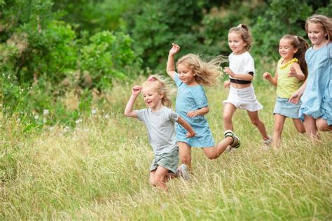 Kids Children Running On Meadow In Summer S Sunlight Stock Image