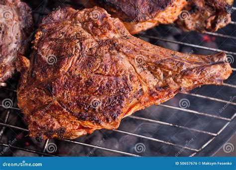 Big Beef Steak With Bone On Grilling Grid Over Barbecue Charcoal Stock