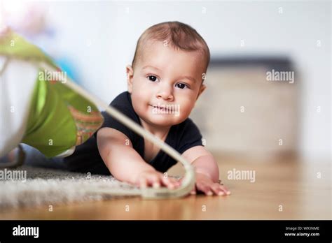 Cute Smiling Baby Boy Crawling On Floor In Living Room Stock Photo Alamy