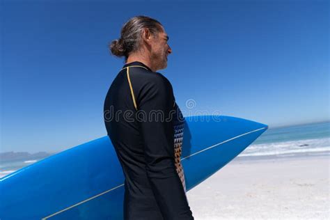 Senior Caucasian Man Holding A Surfboard At The Beach Stock Image