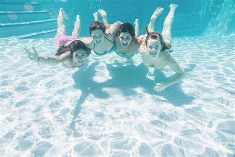 Smiling Caucasian Teenagers Underwater In Swimming Pool Stock Photo