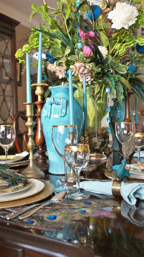 The beachy look was attained in so many different ways like by adding beach themed the centerpiece of a bunch of flowers and the large candle holders were nice accents to this dining room where you can also see a blue glass. Peacock Themed Tablescape | Weddings & Events | Pinterest ...
