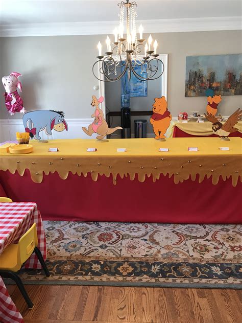 Winnie The Pooh Birthday Party With Decorations And Table Cloths On Top