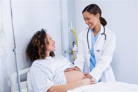 premium photo doctor examining pregnant woman in ward