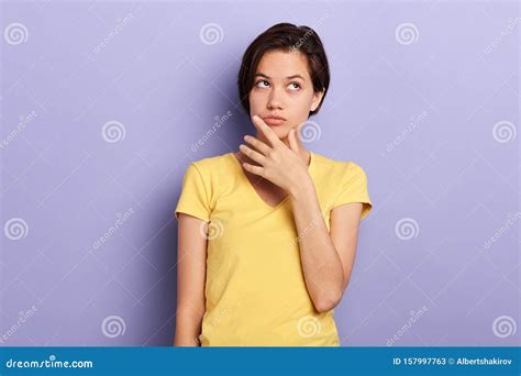 Attractive Girl In Stylish Yellow T Shirt Being Puzzled Solving