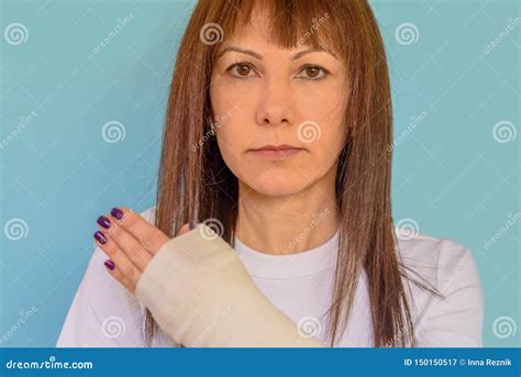Woman With Broken Arm Bone In Cast Plastered Hand On Blue Background