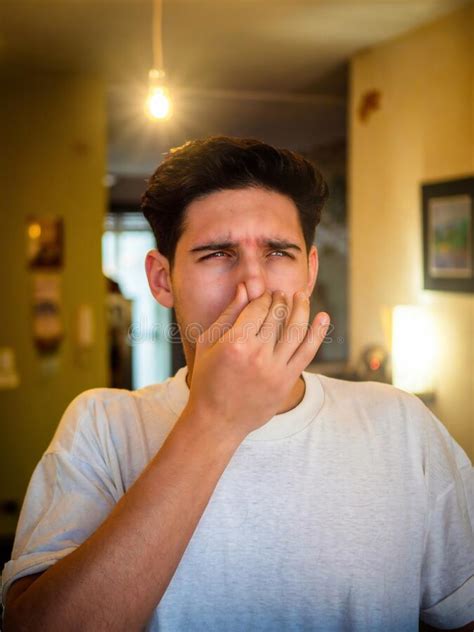 Disgusted Man Pinching Nose In Blurred Room Stock Photo Image Of
