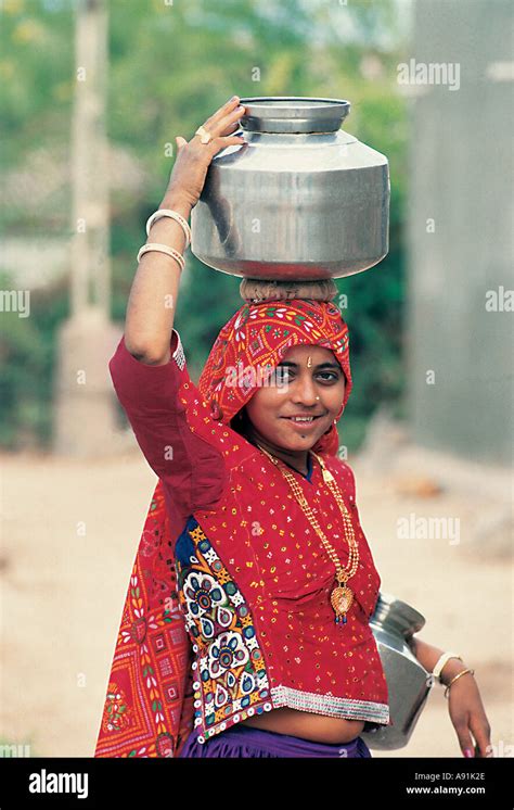 nmj99703 tribal indian women carrying water pot on her head saurashtra kutch gujrat india stock