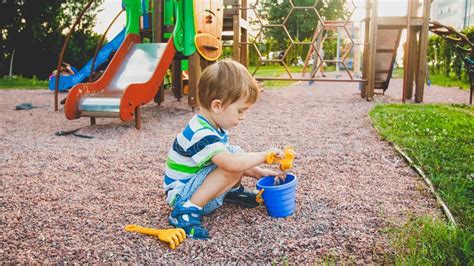Photo Of Adorable 3 Years Old Little Boy Sitting On The Playground And