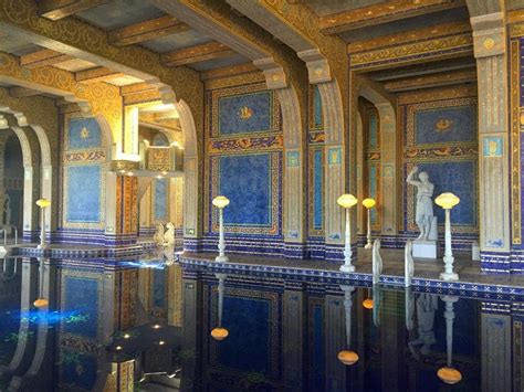An Indoor Swimming Pool With Blue And Gold Tiles On The Walls Along