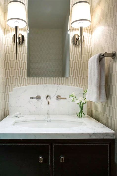 A Powder Room With A Marble Sink And Geometric Wallpaper Features A