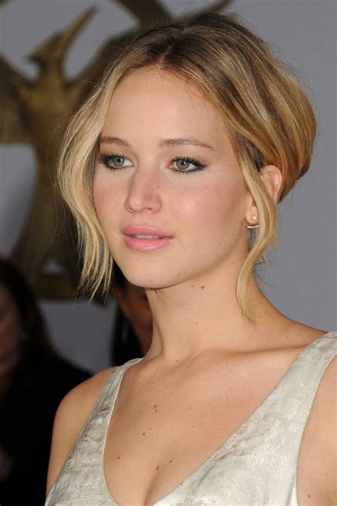 a woman with blonde hair and blue eyes wearing a white dress posing for the camera