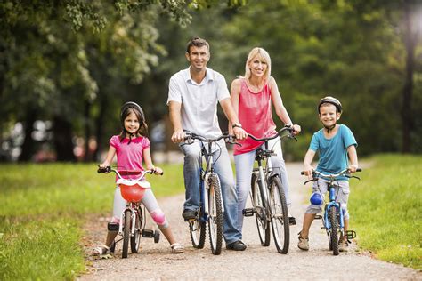 Familia Que Disfruta De Paseo De La Bici En Parque Imagen De Archivo