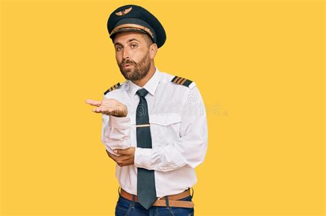Handsome Man With Beard Wearing Airplane Pilot Uniform Looking At The